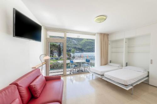 托尔博莱Residence Casa al Sole Apartments的客厅配有红色沙发和电视