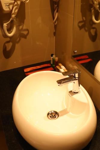 埃尔讷古勒姆Hotel Seven Lights的浴室设有白色水槽和镜子