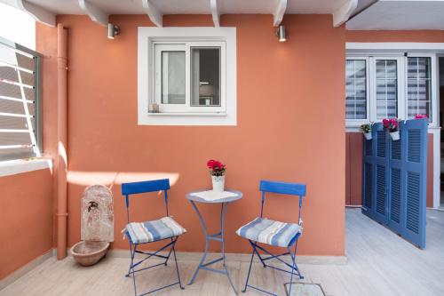 雷夫卡达镇Vicolo Appartamenti Locali by Imagine Lefkada的一间设有两把椅子、一张桌子和一面墙的房间