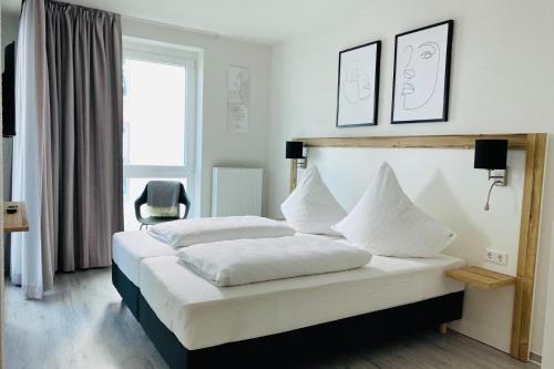 卡珀尔恩Fewo 3-13 Ostsee的一间卧室配有带白色床单和枕头的床。