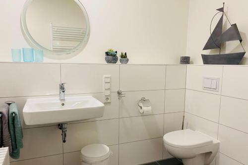 卡珀尔恩Fewo 3-13 Ostsee的一间带水槽、卫生间和镜子的浴室
