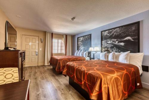 佩森佩森速8汽车旅馆的酒店客房带两张带橙色床单的床