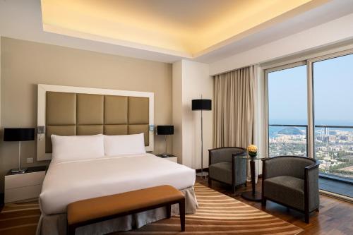 迪拜La Suite Dubai Hotel & Apartments的酒店客房设有一张床和一个大窗户