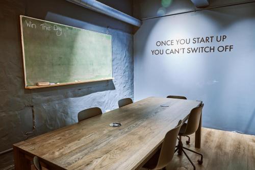 开普敦BlackBrick Cape Town Foreshore的一间设有木桌和黑板的教室