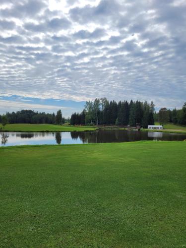 IndrāniBrīvdienu namiņi Kalnozoli的享有高尔夫球场和湖泊的景色