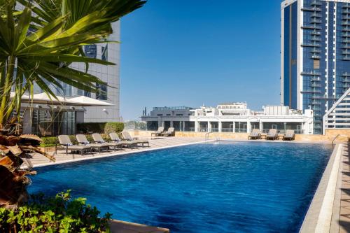 迪拜La Suite Dubai Hotel & Apartments的建筑物屋顶上的游泳池
