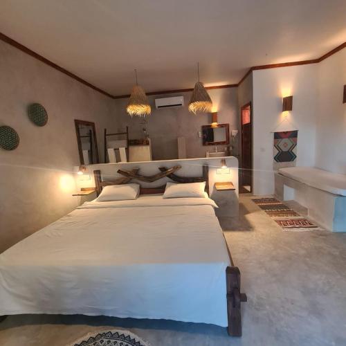 普瓦尼梅查恩加尼Mambo Cabana的卧室配有一张白色大床