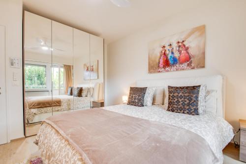 洛迦诺RELAX Camelia Apartment的白色卧室设有一张大床和镜子