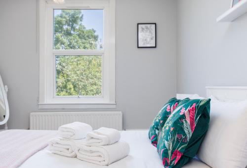 伦敦WelcomeStay Colliers Wood Two Bed Apartment - Home Away from Home的床上的一大堆毛巾