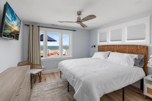 五月岬郡Cape May Ohana Beach Club的一间卧室设有一张大床和一个窗户。