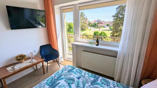 SzczedrzykDom nad Jeziorem的一间卧室设有一张床和一个美景窗户。