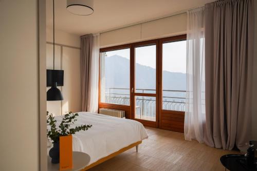 切尔诺比奥Villa ALMANA的一间卧室设有一张床和一个大窗户