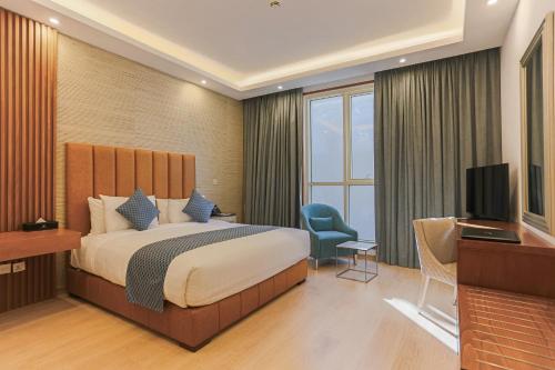利雅德Sarwat Park Hotel Riyadh - Diplomatic Quarter的酒店客房,配有床和电视