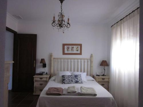 奇克拉纳－德拉弗龙特拉El Magnolio的一间卧室配有一张床,上面有两条毛巾