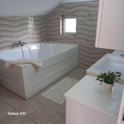 比哈奇Kuća za odmor Lohovo的浴室配有白色浴缸和水槽