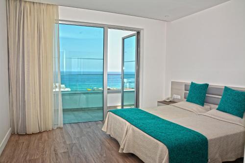 普罗塔拉斯Melini Hotel Suites的一间卧室设有一张大床和一个大窗户