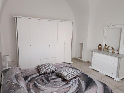 奥里亚LA CASA DEI DESIDERI的一间卧室配有一张大床和白色橱柜。