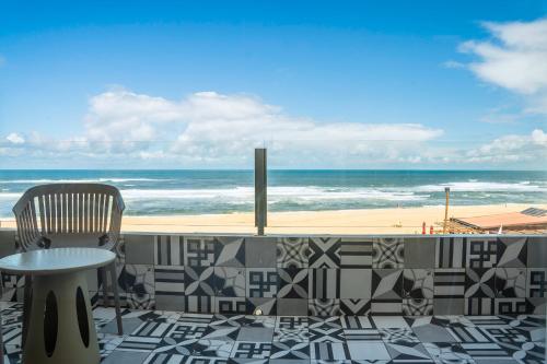 普拉亚达维埃拉Hotel Cristal Vieira Praia & SPA的一个带桌椅的庭院和海滩