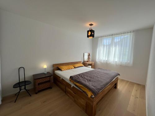科尔斯腾Wohnung auf dem Bürgenstock的一间卧室配有一张床、一张桌子和一个窗户。