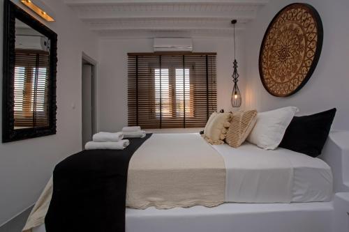 米克诺斯城Nur Mykonian Suites的卧室配有一张带白色床单和枕头的大床。