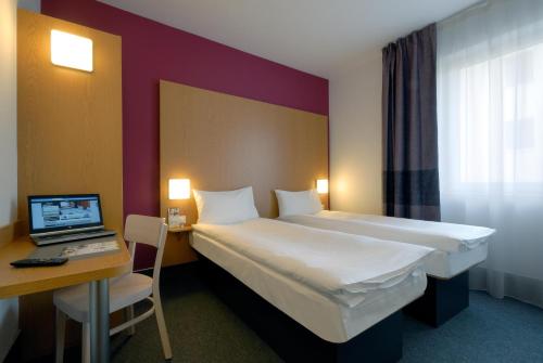布拉格布拉格市住宿加早餐酒店的酒店客房配有一张床、一张书桌和一台笔记本电脑