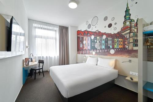 波兹南B&B Hotel Poznań Old Town的一间酒店客房,配有一张白色的床和一张书桌