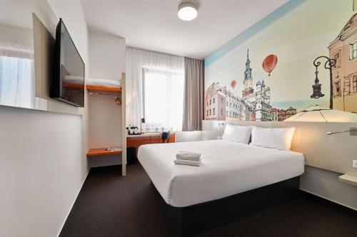 波兹南B&B Hotel Poznań Old Town的一间酒店客房,配有白色的床和电视