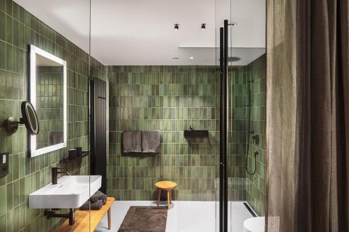 KurdějovGurdau vinařství的浴室铺有绿色瓷砖,配有水槽和淋浴。