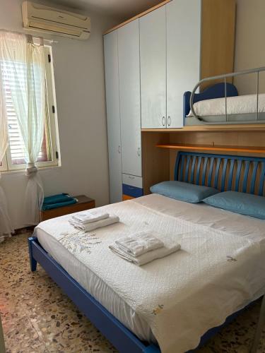 圣多米诺La casetta di India的一间卧室配有一张床,上面有两条毛巾