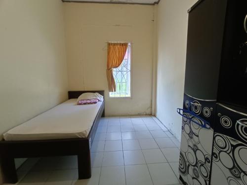 UjungtanjungOYO 92591 Wisma Pangestu Syariah的小房间设有床和窗户
