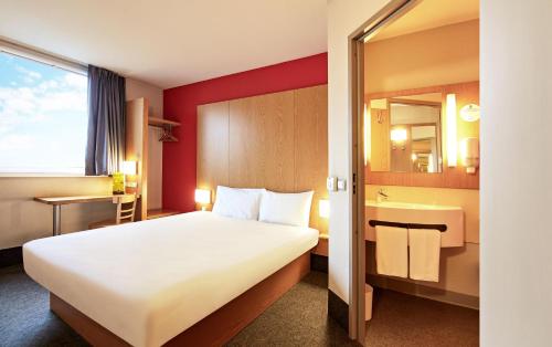 托伦B&B HOTEL Toruń的酒店客房设有一张大床和一间浴室。