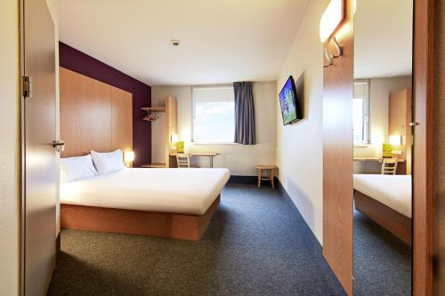 托伦B&B HOTEL Toruń的酒店客房设有两张床和窗户。
