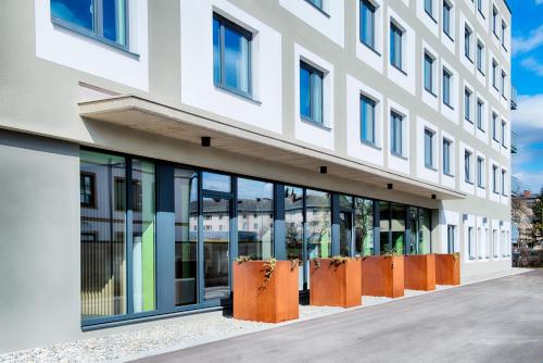 菲拉赫B&B Hotel Villach的一座带大窗户和橙色的办公楼