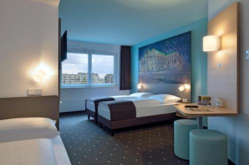 维也纳B&B Hotel Wien-Hbf的酒店客房设有两张床和窗户。