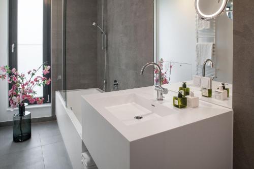 柏林AMANO HOME Apartments的白色的浴室设有水槽和淋浴。