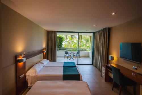 贝尼多姆德鲁斯四星级高级酒店的酒店客房设有两张床和一台平面电视。