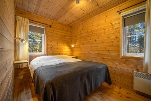 弗罗达尔Gezellige woning met hottub en sauna的木间内的一张床位,设有两个窗户