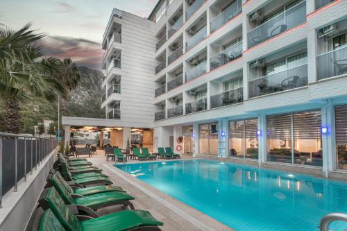 马尔马里斯Arbatt Marmaris Hotel的酒店游泳池的图片,游泳池配有躺椅