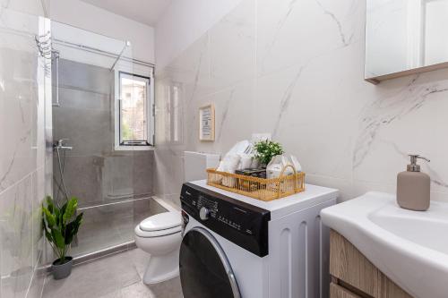 科孚镇Olivia Guest House的浴室设有洗衣机和烘干机,位于厕所旁