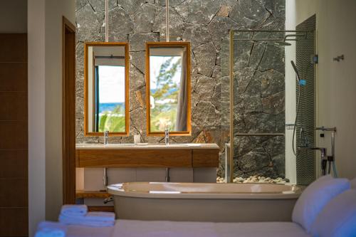 贝尔马尔Beach Penthouse BELMARE的带浴缸、水槽和两面镜子的浴室
