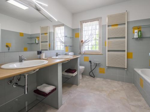 阿斯蒂Casa del Rosmarino的一间带两个盥洗盆、浴缸和卫生间的浴室