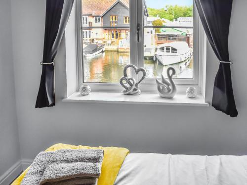 罗克瑟姆Lilys Cottage的卧室内拥有两面心色装饰的窗户