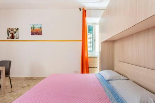 特拉比亚Casa Antonella的一间卧室配有一张带粉红色床罩的床