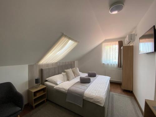 奥巴曹洛克Riviéra Apartmanok的一间卧室配有一张带窗户和椅子的床