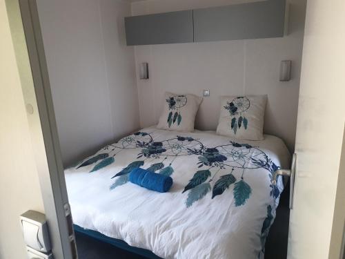 沃洛格河畔格朗热Camping Pré Vologne的一张带蓝色和白色床单及枕头的床