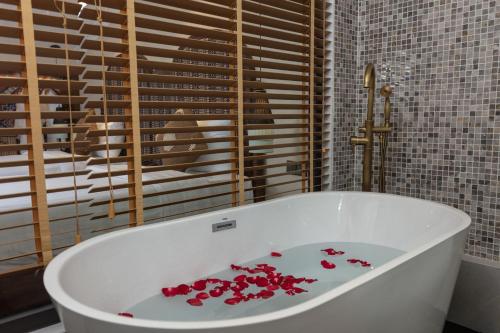 萨帕HOTEL DE SAPA的浴室内装满红色鲜花的浴缸