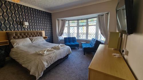 布莱克浦The Kimberley B&B的一间卧室配有一张床和两张蓝色椅子