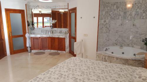莫甘ANFI TOPAZ VILLA TAURO GOLF & BEACH 3 bedrooms 4 bathrooms private pool的带浴缸和盥洗盆的大浴室