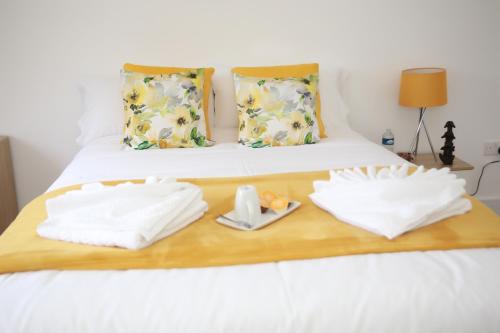 The HydeDeluxe 4 bedroom House的一张带两张毛巾的木托盘床