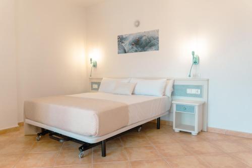 圣安东尼奥Rosamar Ibiza Hotel的一间卧室配有一张床,旁边设有一个床头柜
